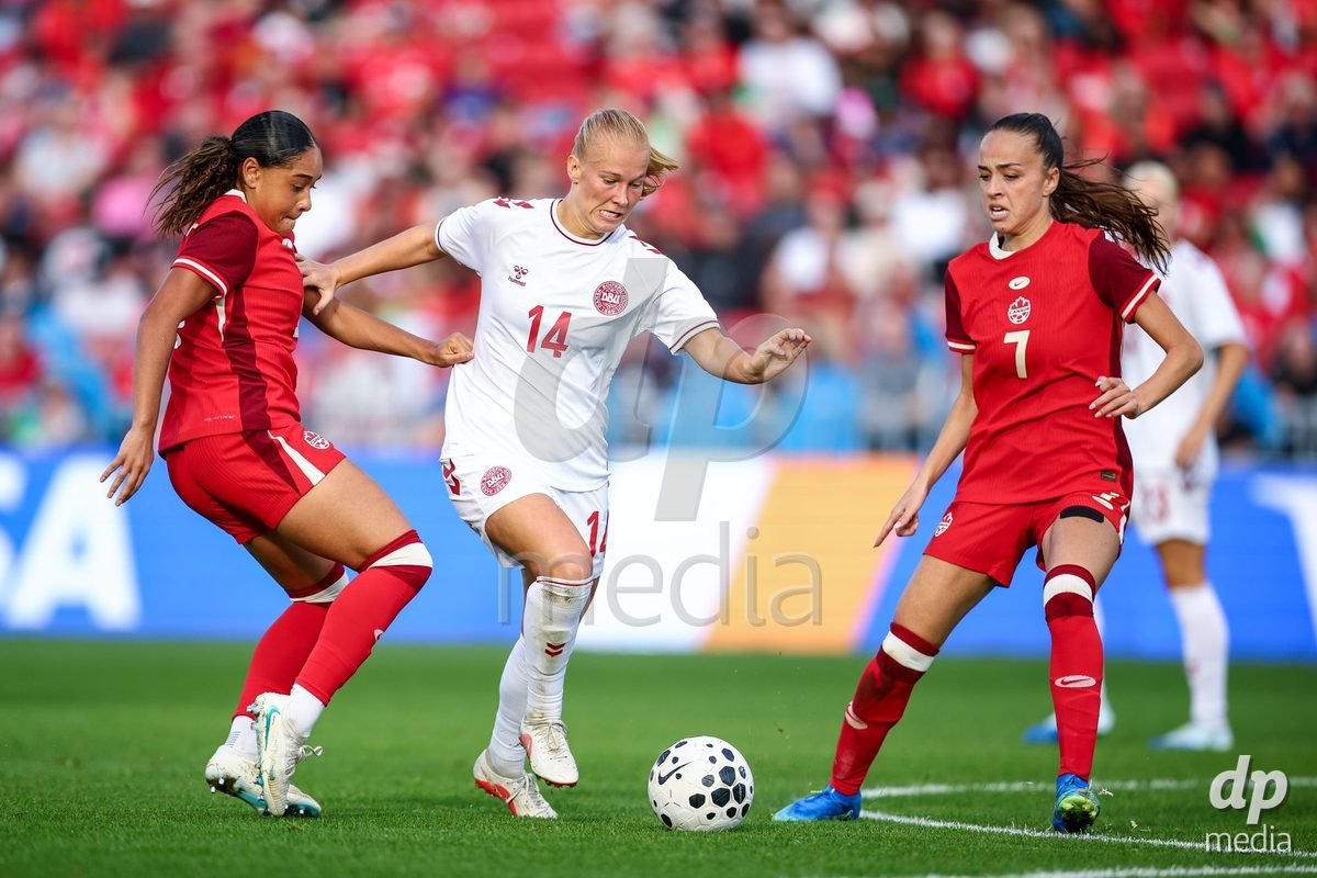 TORONTO, CANADA - OCTOBER 12: Olivia Smith of Canada (L) and Julia Grosso of Canada (R) battle against Sofie Bredgaard of Denmark (C) during the International Friendly match between Canada and Denmark at BMO Field on October 12, 2026 in Toronto, Canada.