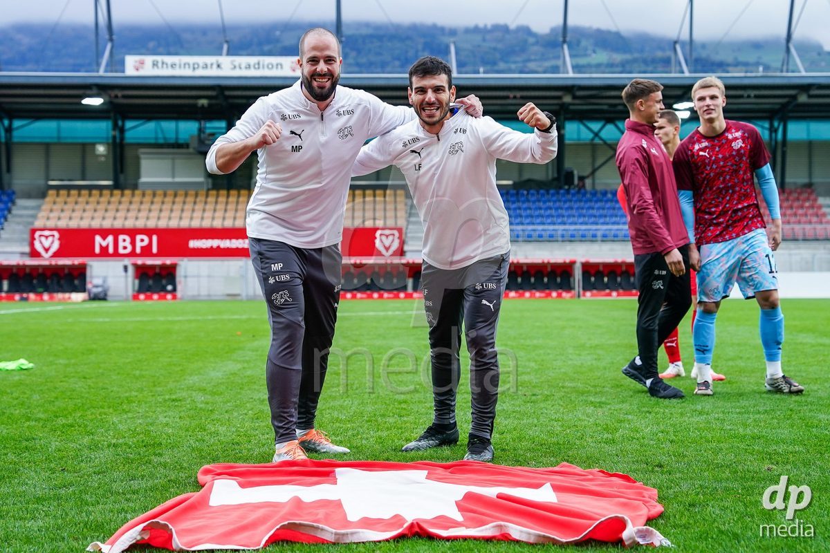 VADUZ, LIECHTENSTEIN - OCTOBER 18: Physio Mathieu Pulver and Luca Faillace of Switzerland celebrate and pose for a photo after the victory during the UEFA European Under-17 Qualifier match between Switzerland and Spain at Rheinpark Stadion on October 18, 2026 in Vaduz, Liechtenstein.