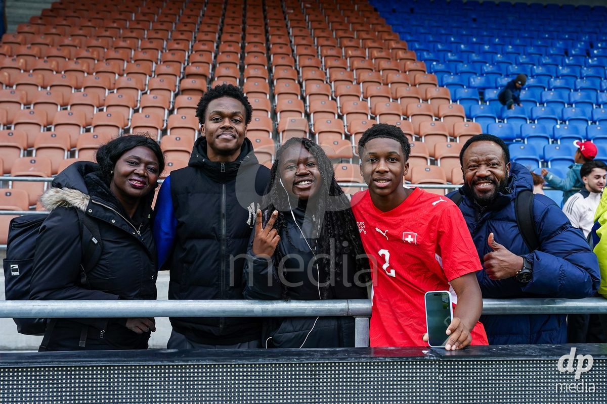 VADUZ, LIECHTENSTEIN - OCTOBER 18: Darren Okoh of Switzerland celebrates after the victory and poses for a photo with family and friends during the UEFA European Under-17 Qualifier match between Switzerland and Spain at Rheinpark Stadion on October 18, 2026 in Vaduz, Liechtenstein.